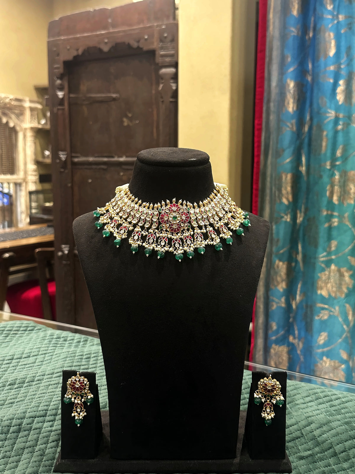 Jadtar Kundan choker necklace with emerald drops and matching earrings on black velvet bust – Studio Gulabi 926ADI202