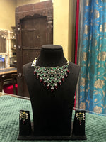 Jadtar moti festive necklace set with green stones, ruby drops and matching earrings on black velvet bust – Studio Gulabi 926HAI079
