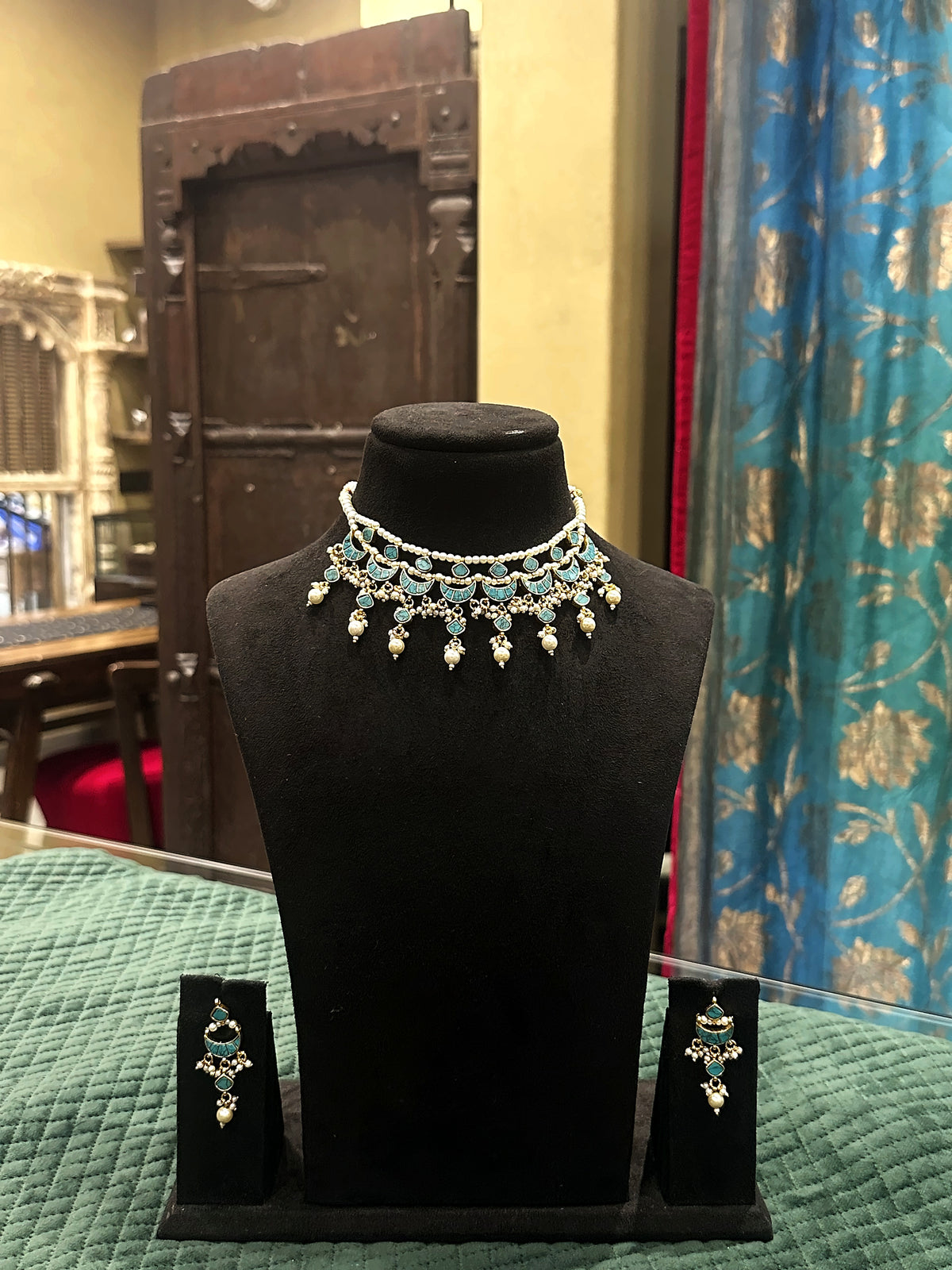 Jadtar and moti choker necklace set with green drops and matching earrings on black velvet bust – Studio Gulabi 726AJI003