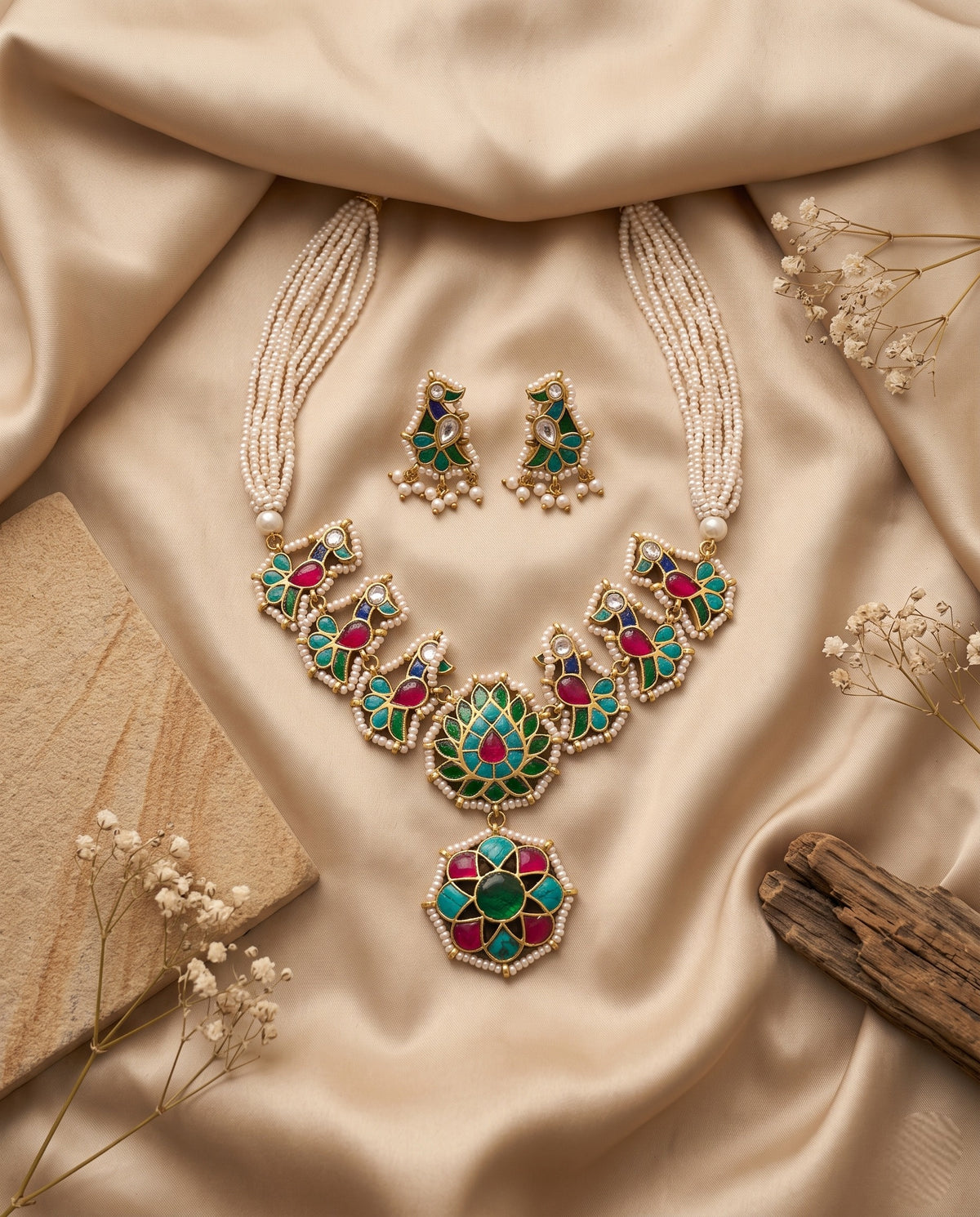 Jadtar pearl necklace set with green and ruby pendant and matching earrings styled on satin – Studio Gulabi