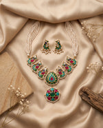 Jadtar pearl necklace set with green and ruby pendant and matching earrings styled on satin – Studio Gulabi