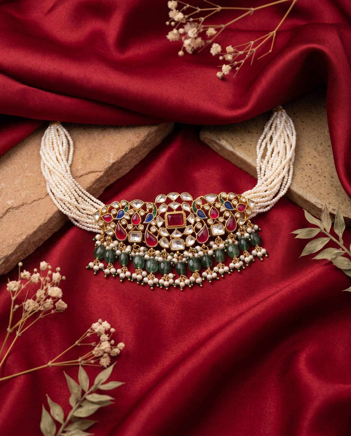 Kundan moti mala choker with ruby and emerald drops and matching earrings styled on satin – Studio Gulabi